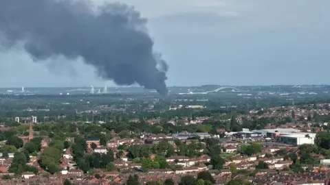 Altano Drone Photography A large plume of smoke can be seen billowing up into the sky, with the Runcorn bridge visible in the distance.