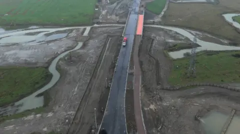 Leicestershire County Council An aerial view of a road crossing a river and next to a construction site
