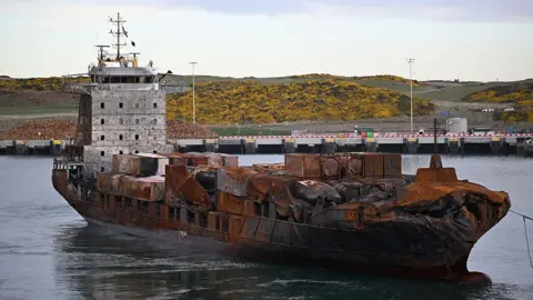 The Solong with damage to its bow and burn marks along the hull and bridge area 