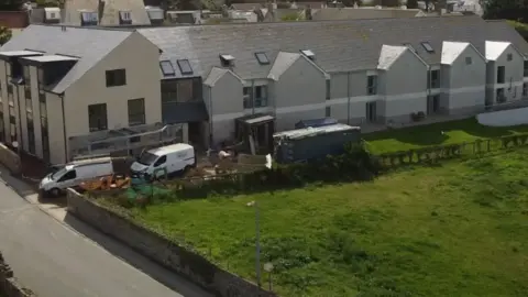 A two-storey block with new two-storey units and what appears to be construction work going on.