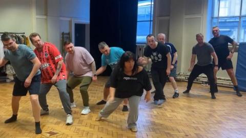 Dads rehearsing a dance routine with their tutor at NAPA in Hull