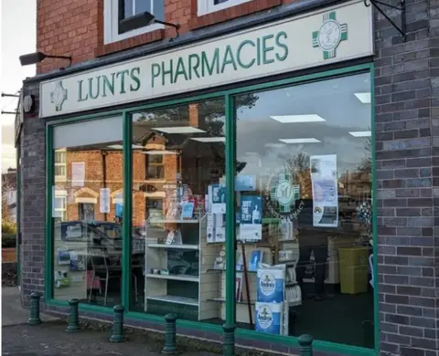 John Ingham The shop front of Lunts Pharmacy in Shropshire. It has a white sign with green lettering saying 'Lunts Pharmacies'