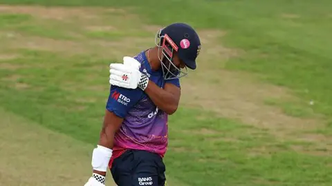 Emilio Gay clutching his right shoulder during Durham's match with Middlesex