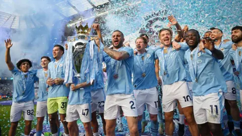 Manchester City captain Kyle Walker lifts the Premier League trophy at City's Etihad Stadium in May 2024