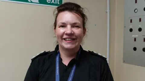 Sarah Sleaford head-and-shoulders photo, she is wearing black police uniform, smiling.