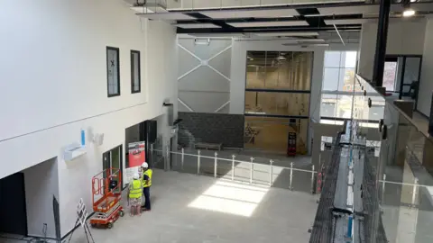 Tom MacDougall/BBC The spacious interior of the main space in the building, taken from a balcony on the second floor, and which shows access to a large sports hall.