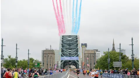 PA Media Runners taking part in the Great North Run crossing the Tyne Bridge