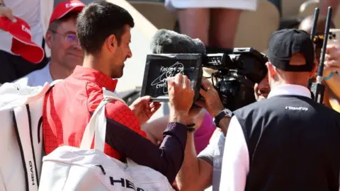 Getty Images Novak Djokovic of Serbia writes in Serbian on the camera lens a political statement, 'Kosovo is the heart of Serbia. Stop the violence'