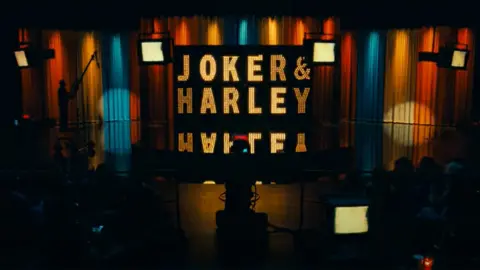 Warner Bros Shot from Joker 2 showing an illuminated sign saying "Joker & Harley"