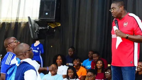 Living Streams International Man in Arsenal shirt looking down from the stage