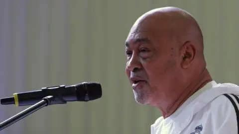 Getty Images Suriname's President Desi Bouterse, addresses the public before taking part in a yoga class on the 4th International Yoga Day in Paramaribo, Suriname on June 21, 2018.