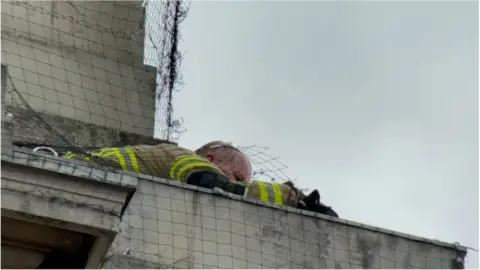 PAul Wheatley Fire fighter crawling on to the ledge