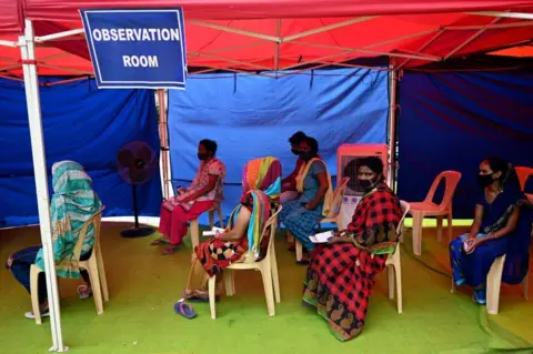 Getty Images People wait in an observation area after receiving a dose of the Covaxin vaccine against the Covid-19 coronavirus at a vaccination centre in New Delhi on September 29, 2021.