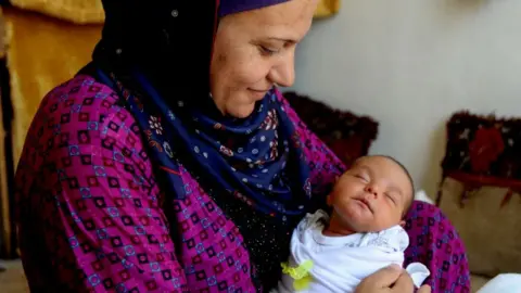 Getty Images A Syrian refugee holds her newborn girl in Beirut