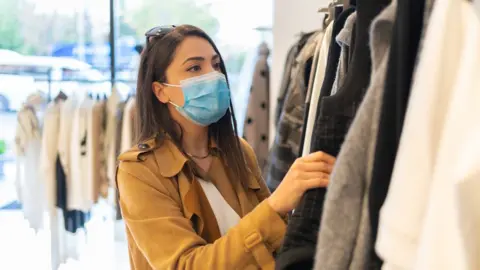 Getty Images Woman wearing a mask shopping