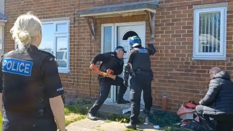 Cleveland Police Officers breaking down a door
