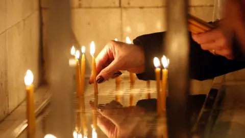 EPA A person lighting up candles