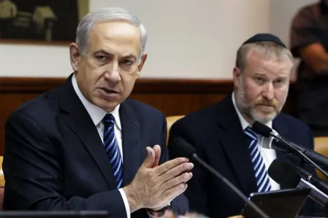 AFP File photo showing Israeli Prime Minister Benjamin Netanyahu and Attorney General Avichai Mandelblit at a cabinet meeting (19 May 2013)