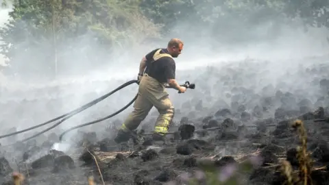 Getty Images Firefighters contain a wildfire that encroached on nearby homes in the Shiregreen area of Sheffield, 20 July 2022
