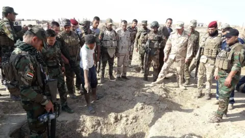 AFP/Getty Images Iraqi forces inspect a mass grave near Hawija, 11 Nov 2017