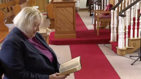 Bishop Groves in church reading the bible