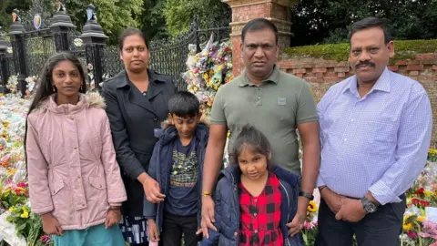 Kate Scotter/BBC Premi Kamalanathan with her husband Rasalingam Kamalanathan, his dad Velu Kamalanathan and children Shobika, Subiksha and Harini