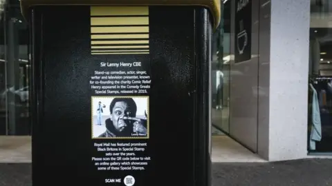 PA Media A black postbox featuring an image of Sir Lenny Henry in Bedford Street, Belfast