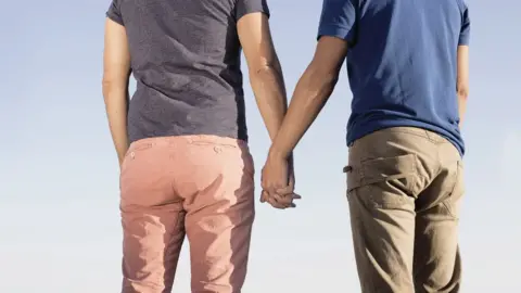 Science Photo Library Two men holding hands