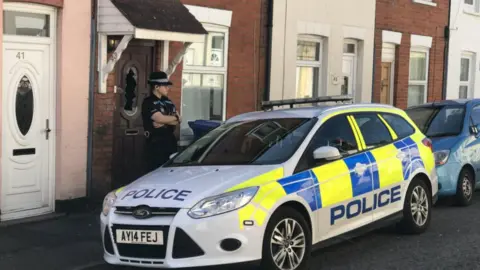 BBC Police officer outside terraced house