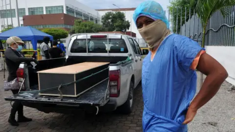 AFP Man in protective kit to identify a relative in a morgue, Guayaquil, 15 Apr 20