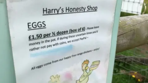 A sign with eggs for sale