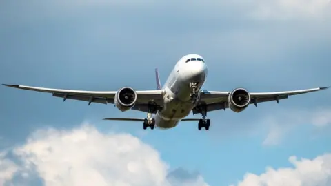 Getty Images Plane flying in blue sky