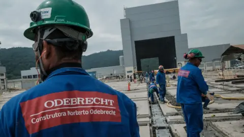 Getty Images worker in hard hat with Odebrecht logo on back of uniform