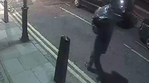 Met Police CCTV of person carrying bin bag