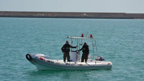 Getty Images Two Tunisian Coast Guards on board a boat