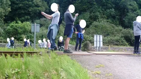 Network Rail People post for selfies on a level crossing in Harlech