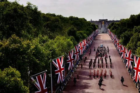 Victoria Jones The coffin of Queen Elizabeth II, draped in the Royal Standard with the Imperial State Crown placed on top, is carried on a horse-drawn gun carriage of the King's Troop Royal Horse Artillery, during the ceremonial procession from Buckingham Palace to Westminster Hall