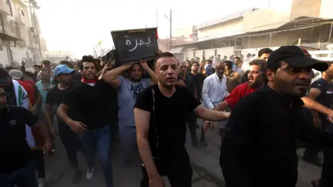 EPA Iraqi mourners carry the coffin of a protester who was killed during clashes in Basra, 7 September 2018