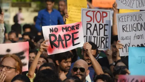 Getty Images Indian demonstrators hold placards during a protest in support of rape victims following high profile cases in Jammu and Kashmir and Uttar Pradesh states