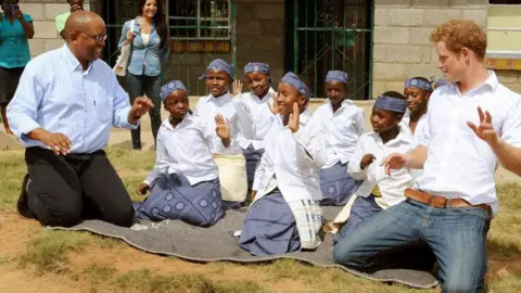 PA Media Prince Harry and Lesotho's Prince Seeiso, join in with a kneeling dance at the Kananelo Centre for the Deaf, in the Maseru district of Lesotho - February 2013