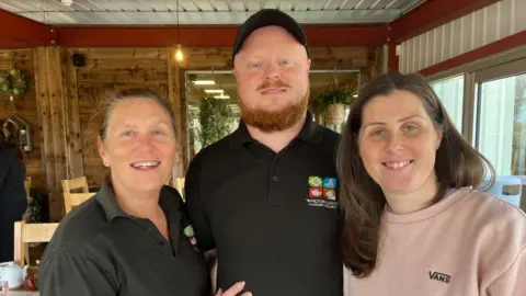 MOD Ashleigh and Dave Loach with Jackie Hunt standing at a garden centre