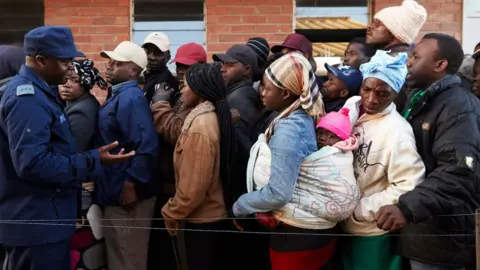 AFP People queue early morning on 30 July 2018 at a polling station in the Harare suburb of Chitungwiza, Zimbabwe