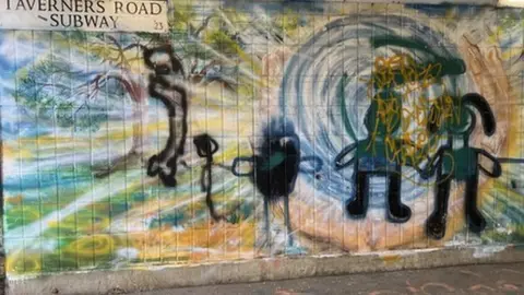 Emma Baugh/BBC Image of a mural over painted with stick people