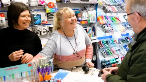 Sandra Jervis in her shop with a colleague and customer