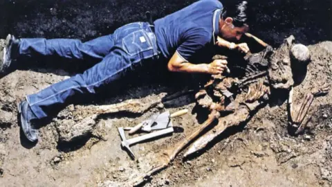 Parco Archeologico di Ercolano An archaeologist uncovers a skeleton at Herculaneum