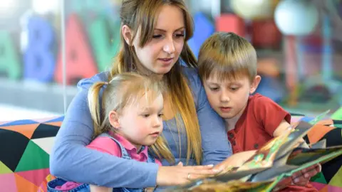 Getty Images Au pair reading to two children