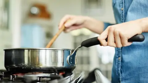 Getty Images Person cooking on a gas hob