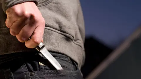 Getty Images Man with knife in pocket