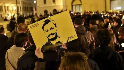 AFP A woman holds a picture of Giulio Regeni at a demonstration in front of the Italian parliament on the first anniversary of his disappearance (25 January 2017)