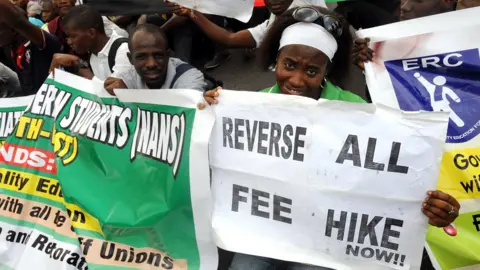 AFP Students and workers carry placards as they sit on the Lagos-Ikorodu highway to protest against the suspension of academic activities